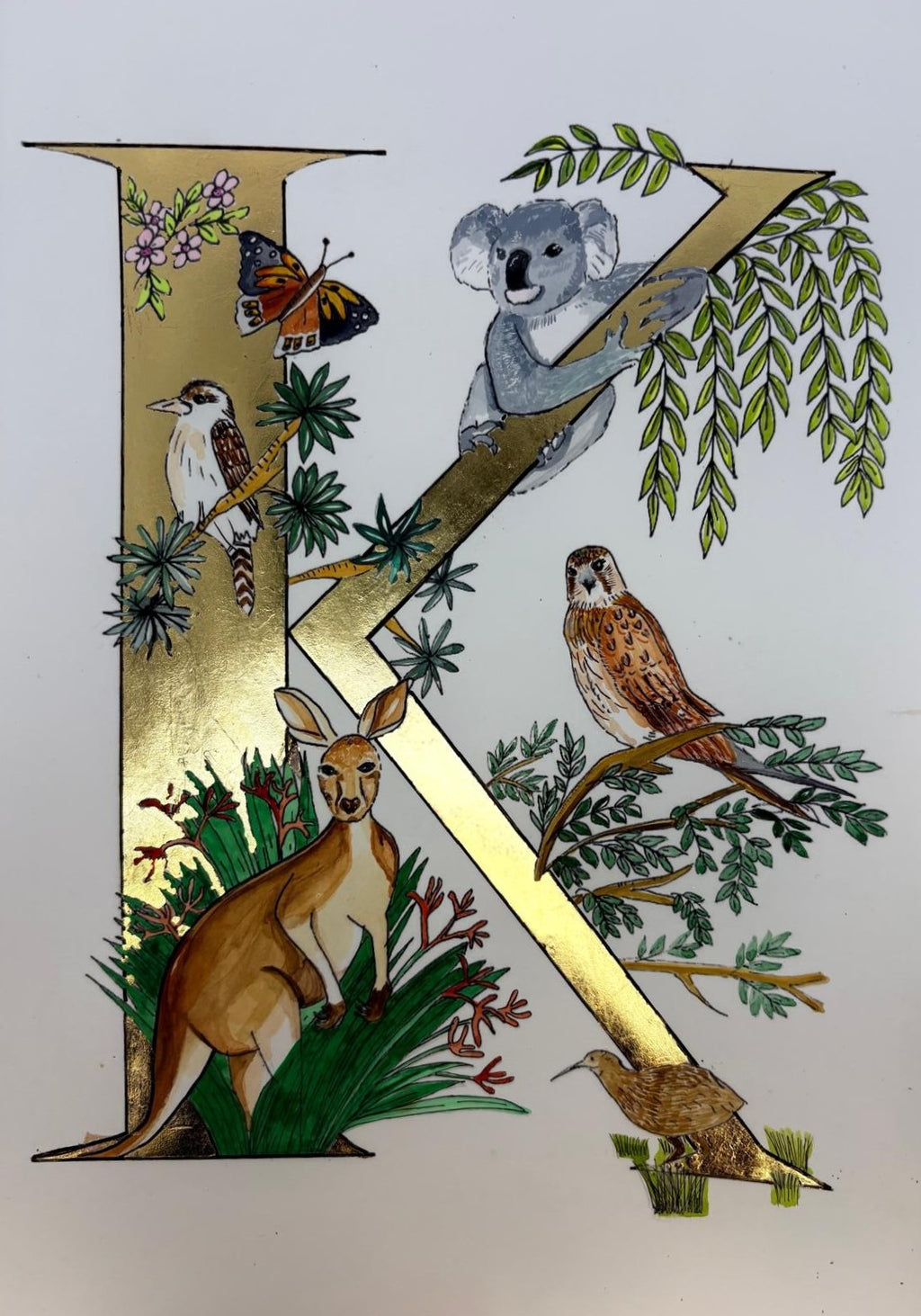 Letter 'K' with Australian animals and nature elements on a white background