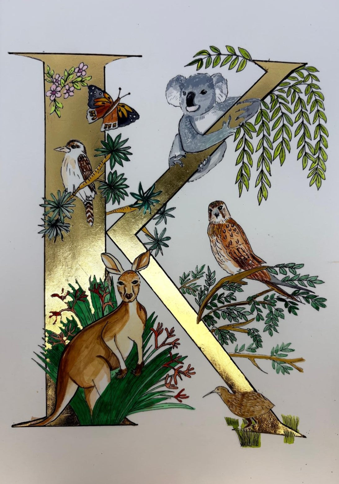 Letter 'K' with Australian animals and nature elements on a white background